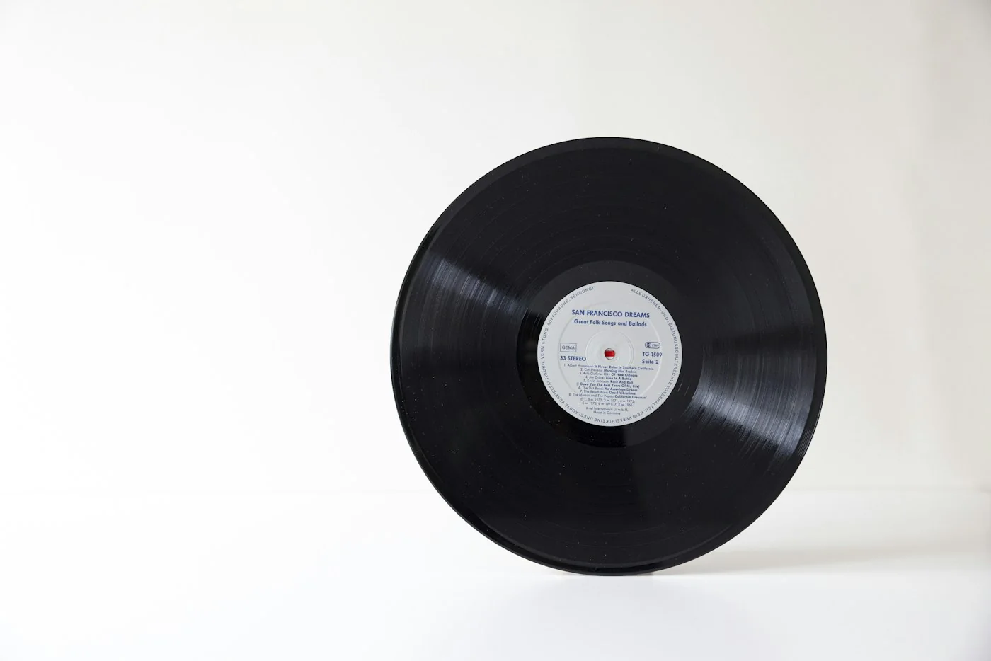 A vinyl record standing on a white surface.