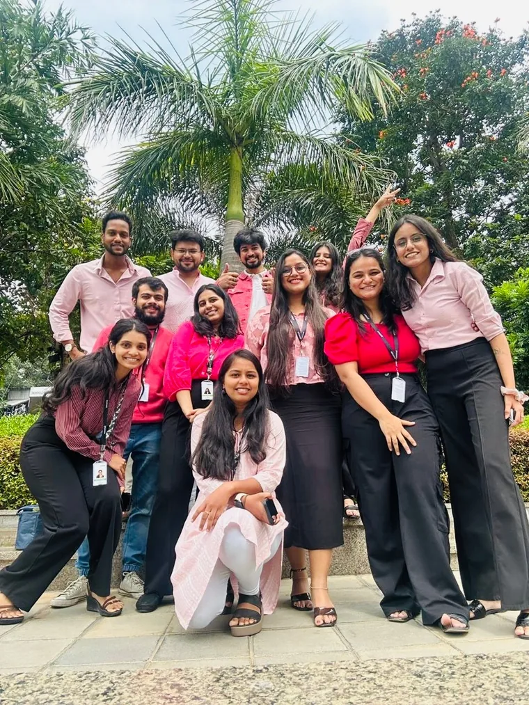 The Deloitte team dressed in pink, posing under a palm tree.