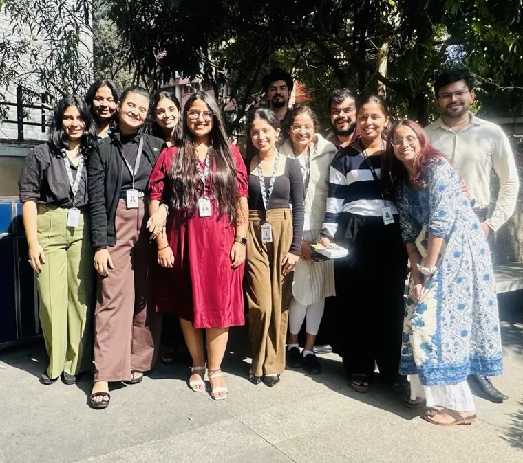 Vibha with ten colleagues from the Deloitte team, outdoors in the sun.