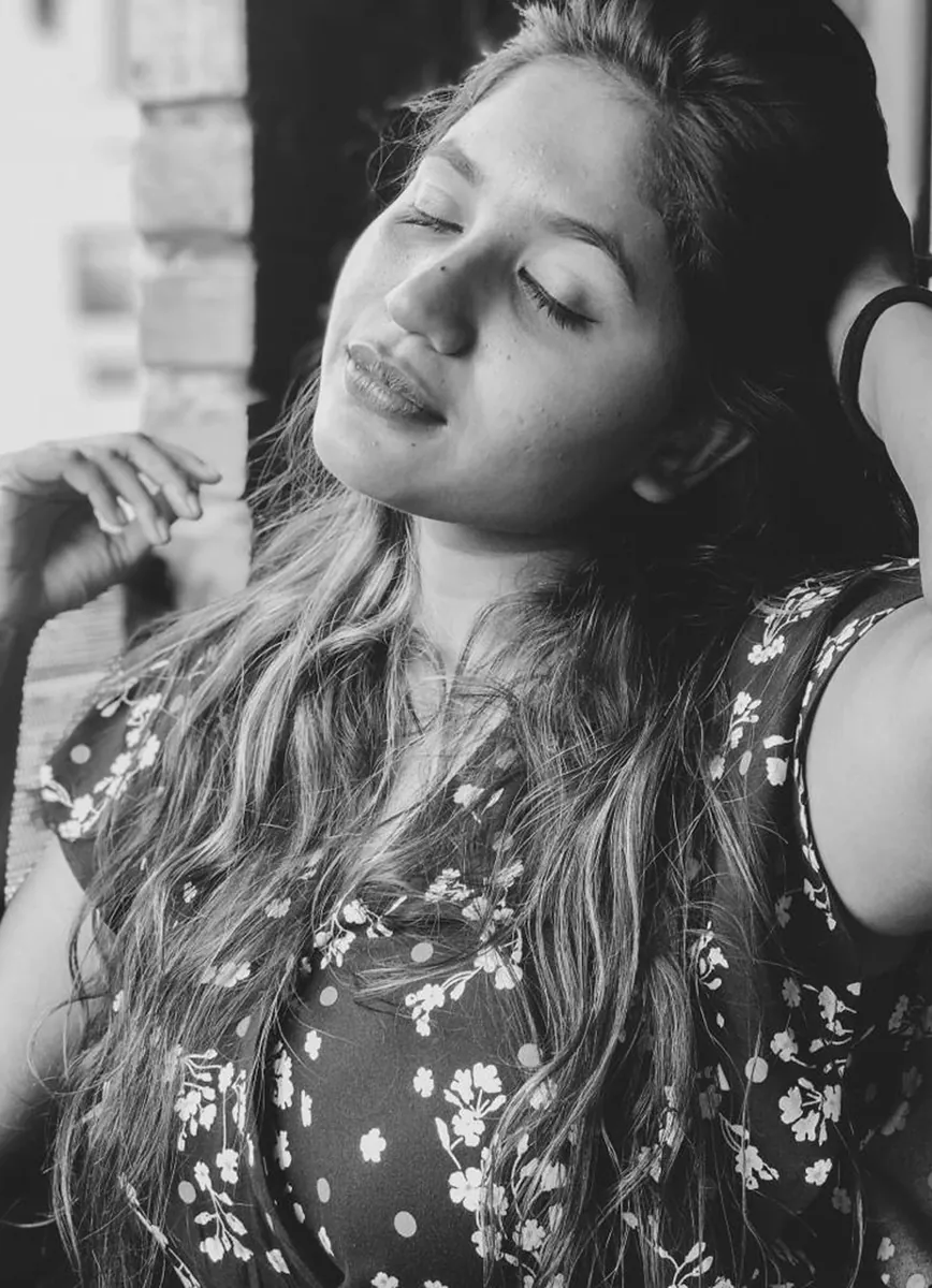 Black and white portrait of a woman with eyes closed, head tilted into window light.